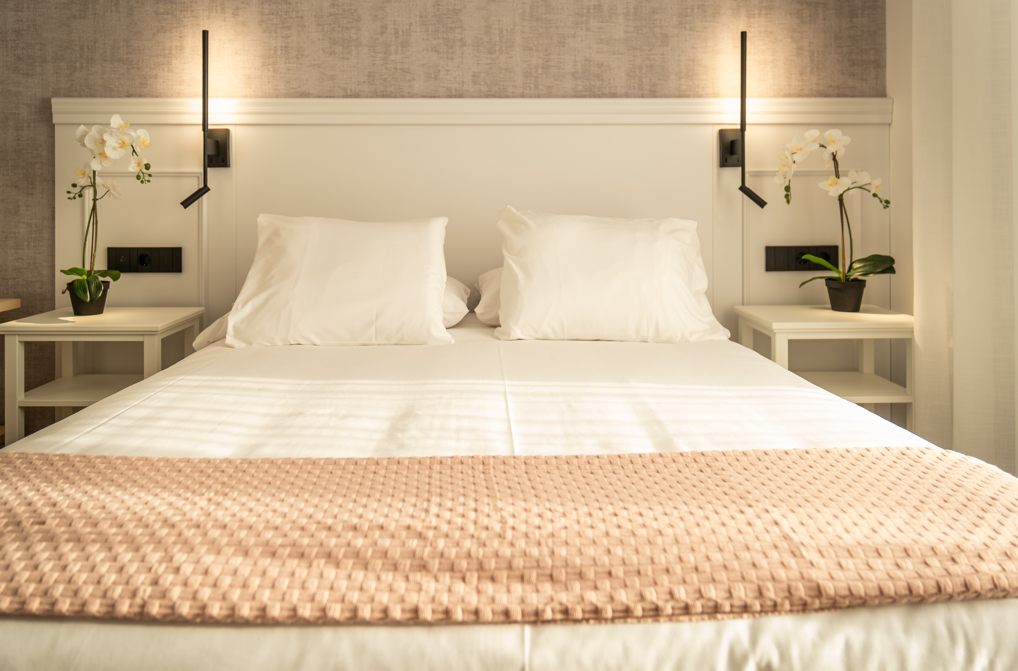 Cabecero con orquídeas y ropa de cama de calidad